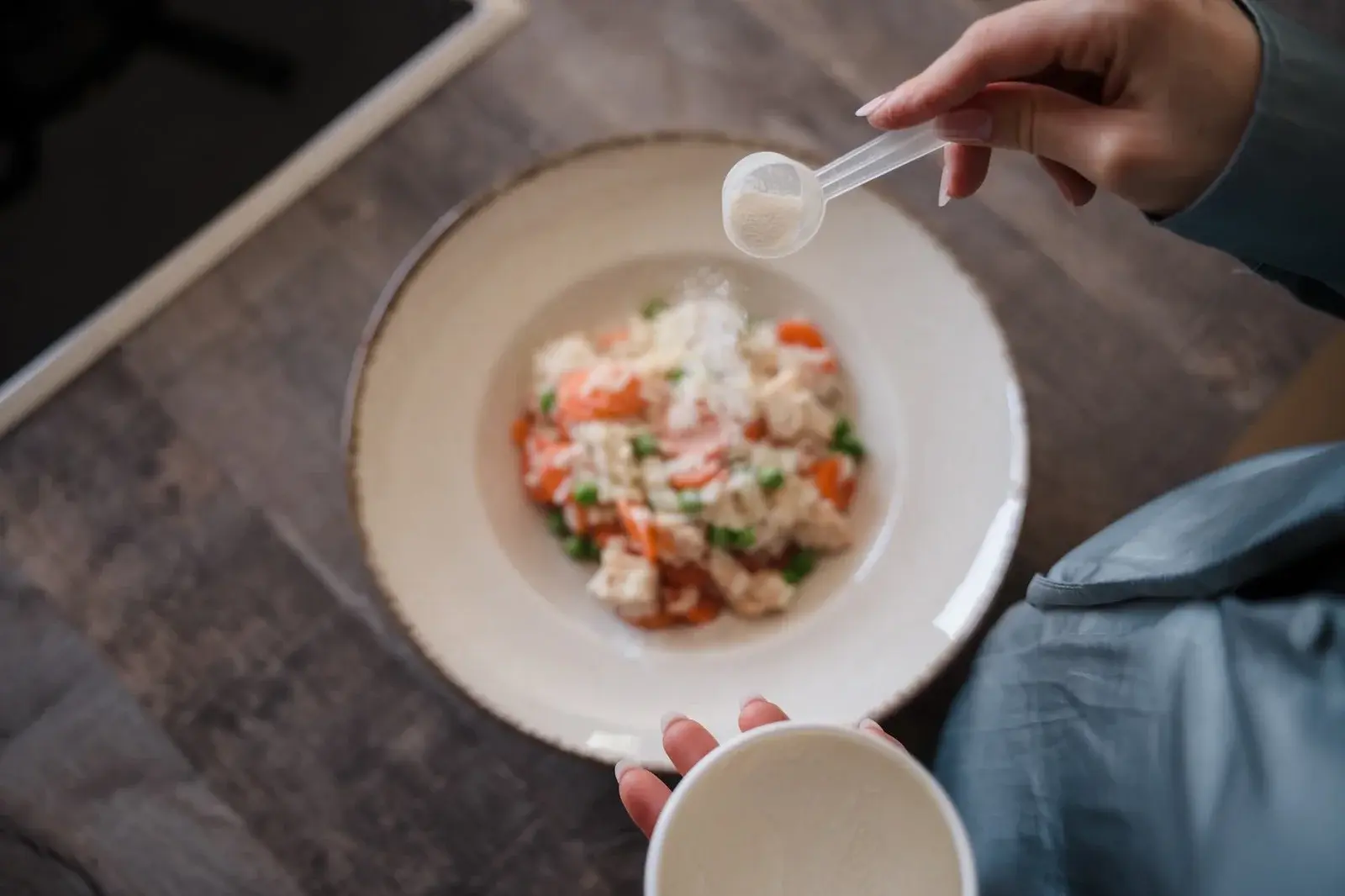 Enzyme powder being sprinkled directly onto a healthy meal